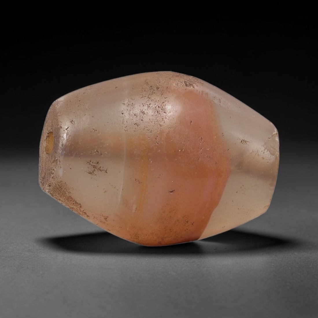 Ancient Agate Bead - Silk Road Bicone Amulet: Carved from banded agate (carnelian variant), the bead features a smooth symmetrical bicone (double-pointed) form with a polished surface that highlights the stone's striking central warm orange-pink