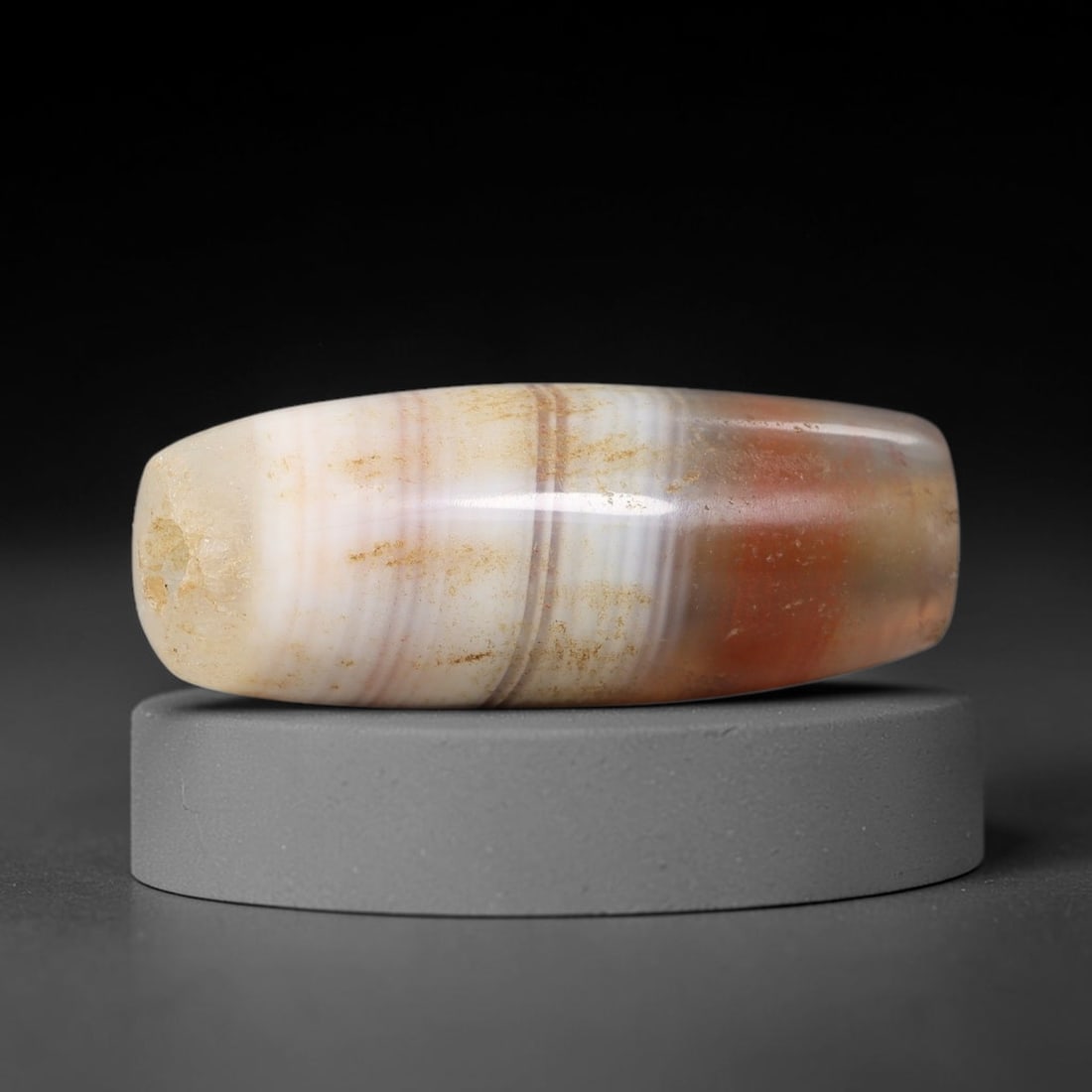 Ancient Agate Bead - Silk Road Cylinder Amulet: Carved from banded agate, the bead features a cylindrical barrel form with a smooth, polished surface that highlights the stone's natural concentric banding, ranging from creamy white and soft taupe t