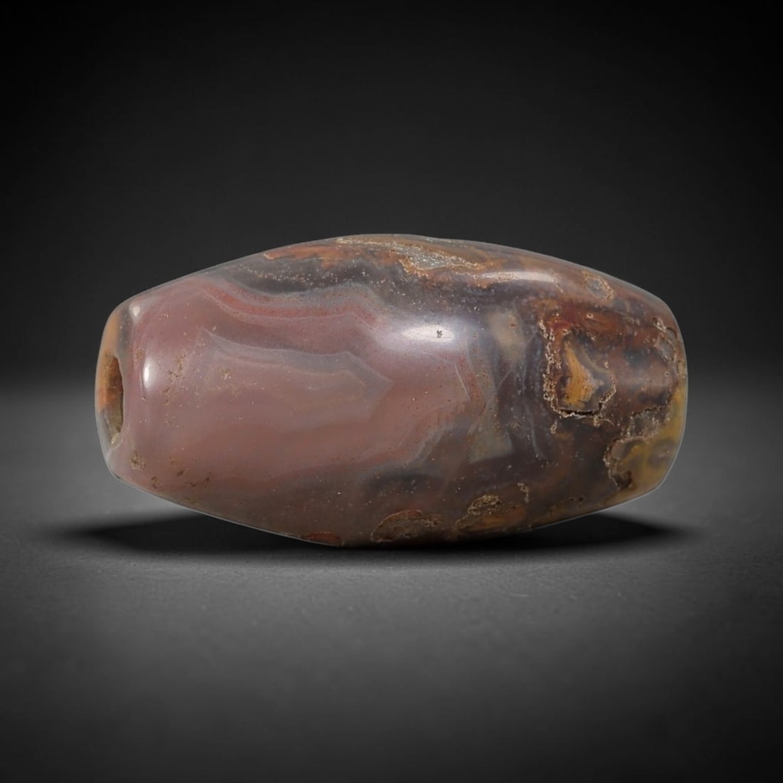 Ancient Agate Bead - Silk Road Cylinder Amulet: Carved from banded agate, the bead features a cylindrical barrel form with a smooth, polished surface that highlights the stone's natural concentric banding, ranging from soft rose-pink and smoky gray