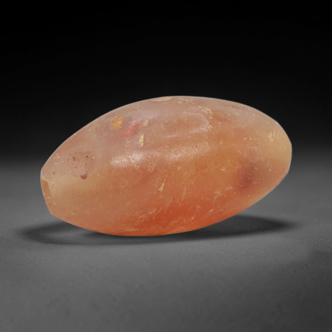 Ancient Carnelian Bead - Indus Valley Bactrian Pendant: This bead is masterfully carved from natural carnelian, showcasing exceptional lapidary craftsmanship consistent with ancient bead-making traditions of the Indus Valley and Bactrian regions. The elong