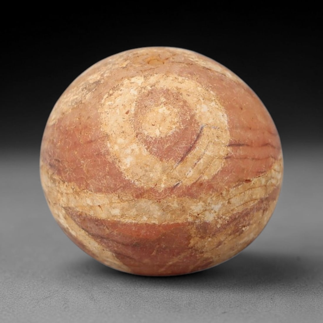 Ancient Carnelian Etched Bead - Gandhara Archaeological Find, 27BE: Carved from natural carnelian, the bead is spherical in form, adorned with white etched concentric circular and linear band motifs across its surface. A lateral drilled suspension hole is present, cha