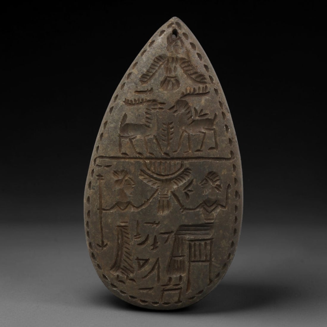 Near Eastern Tribal Stone Plaque Amulet - Figural Ritual Plaque, 2ZY: Carved from a single piece of stone, this teardrop-shaped relief amulet features a detailed two-tiered figural composition in the stylized, linear artistic tradition of Near Eastern tribal art. The up