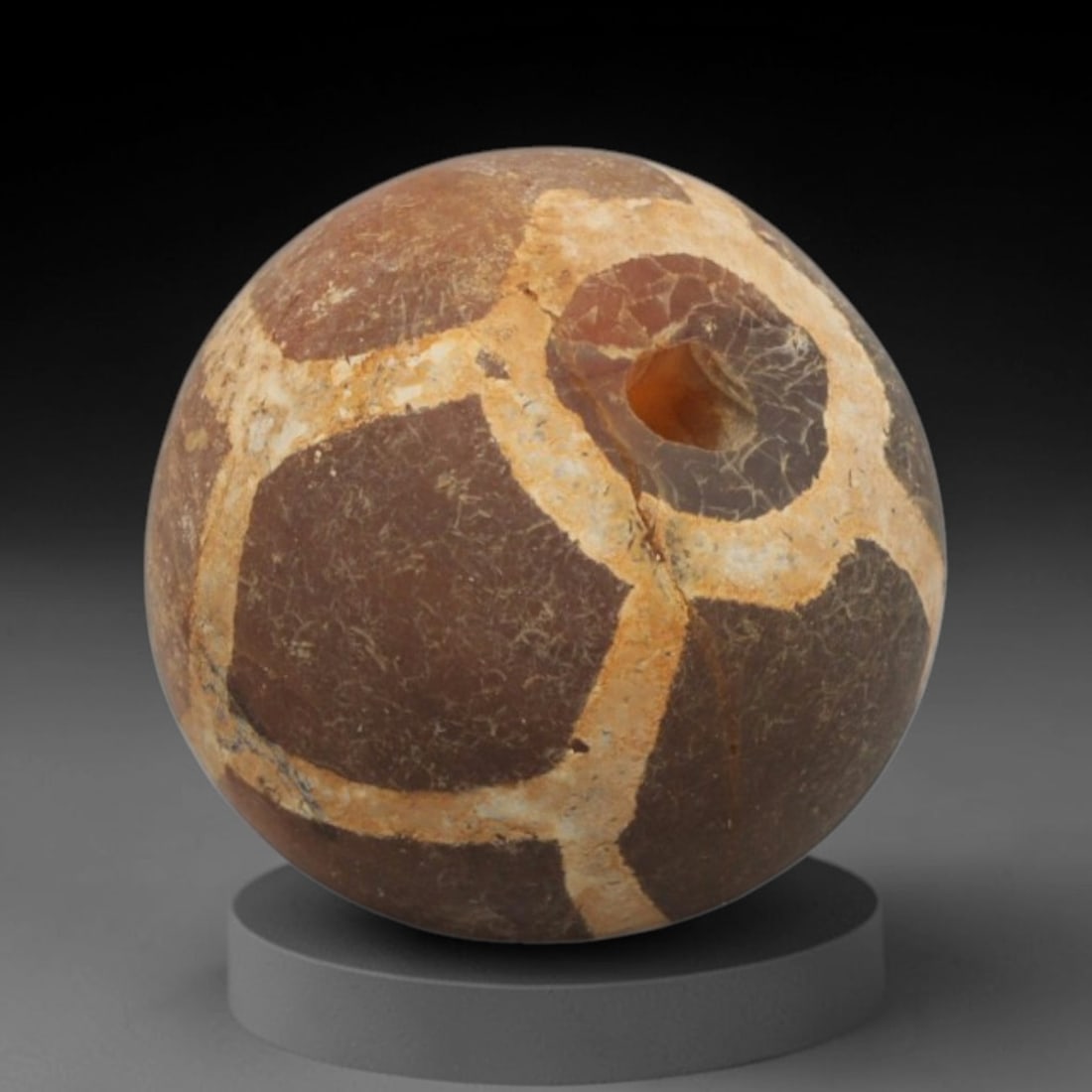 Ancient Carnelian Etched Bead - Gandhara Spherical Bead, 12XY: The bead is crafted from carnelian, a semi-precious chalcedony, with a spherical form and laterally drilled suspension hole. Its surface features an etched white geometric lattice pattern, created usi