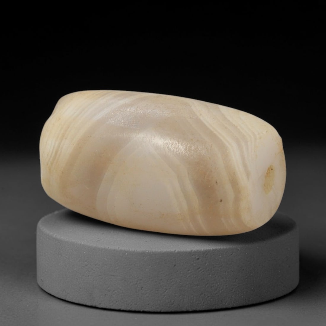 Ancient Agate Bead - Indus Valley Banded Barrel Bead, 28XW: This bead is carved from translucent creamy-white and pale beige banded agate, shaped into a smooth, compact barrel form with a precisely centered axial drill hole, characteristic of Indus Valley (Har