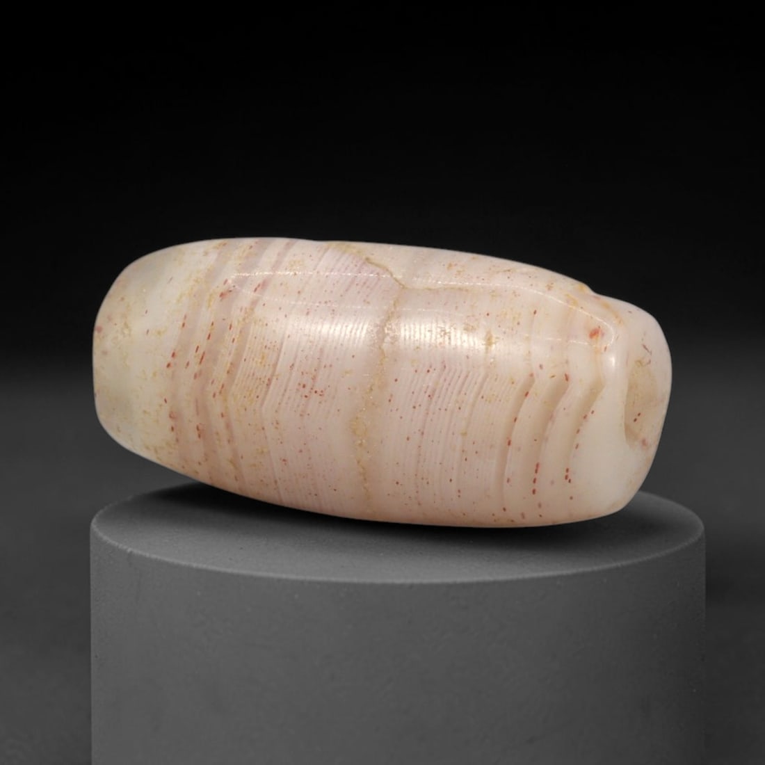 Ancient Agate Bead - Western Asiatic Silk Road Amulet, 73XW: This bead is crafted from translucent agate with a soft pinkish base, fine concentric banding, and scattered red iron oxide inclusions, characteristic of ancient lapidary traditions from the Western A