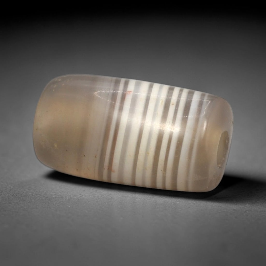 Ancient Banded Agate Bead - Western Asiatic Miniature Amulet, 5XY: This bead is masterfully carved from naturally banded translucent agate, showcasing exceptional lapidary craftsmanship consistent with ancient bead-making traditions of the Indus Valley and Bactrian r