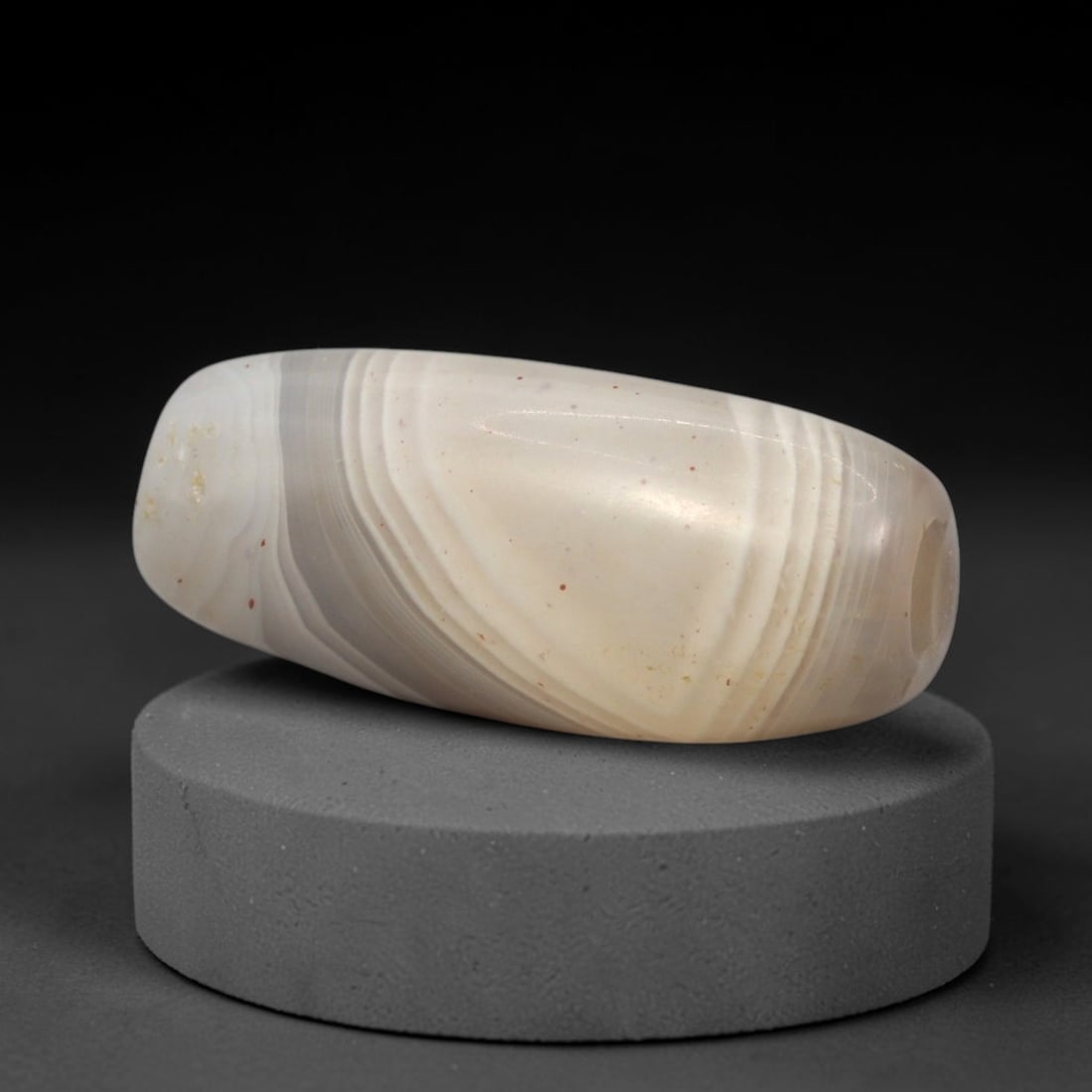 Ancient Banded Agate Bead - Western Asiatic Silk Road Amulet, 61XW: This bead is crafted from translucent banded agate with distinct swirling chevron-style stratification, a soft greyish base, and scattered red iron oxide inclusions, characteristic of ancient lapidary