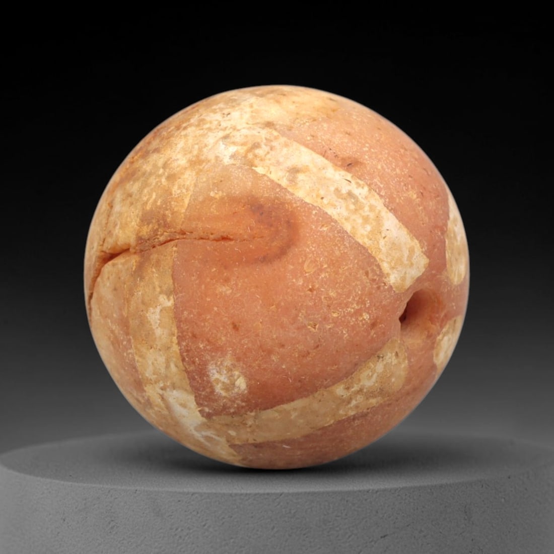 Ancient Carnelian Etched Bead - Gandhara Spherical Bead, 53XY: The bead is crafted from carnelian, a semi-precious chalcedony, with a spherical form and lateral drilled suspension hole. The surface features etched white geometric banding, characteristic of Gandha