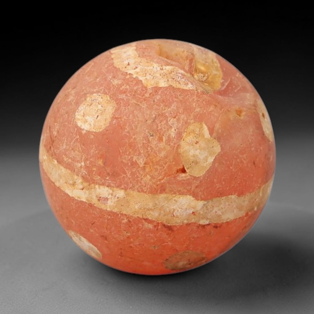 Ancient Carnelian Etched Bead - Gandhara Archaeological Find, 6BE: Carved from natural carnelian, the bead is spherical in form, decorated with white etched linear band and circular dot motifs across its surface. A lateral drilled suspension hole is present, consiste