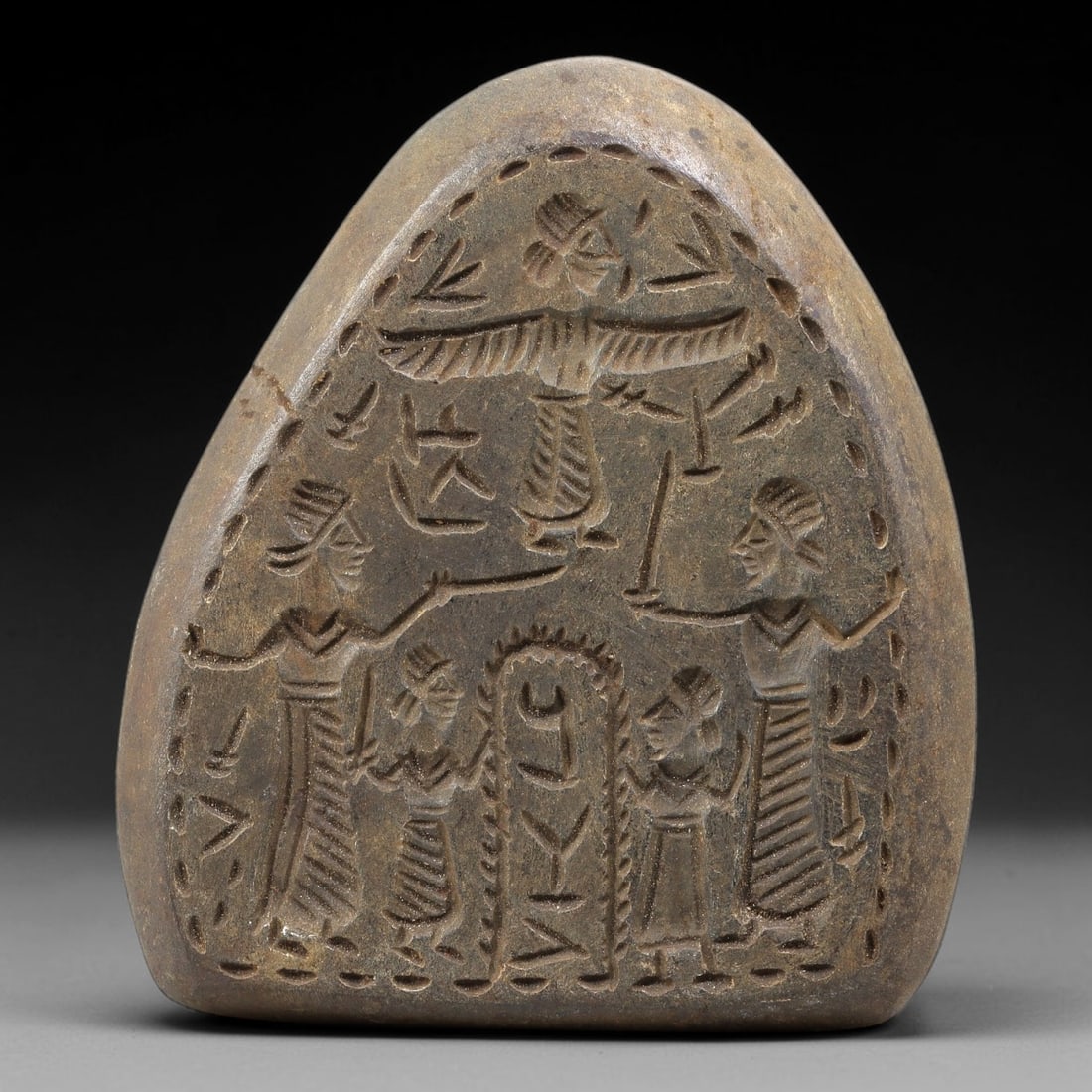 Near Eastern Tribal Stone Plaque Relief - Figural Ritual Plaque, 78BE: Carved from a single piece of stone, this triangular relief plaque features a detailed figural composition in the stylized, linear artistic tradition of Near Eastern tribal art. The central scene depi