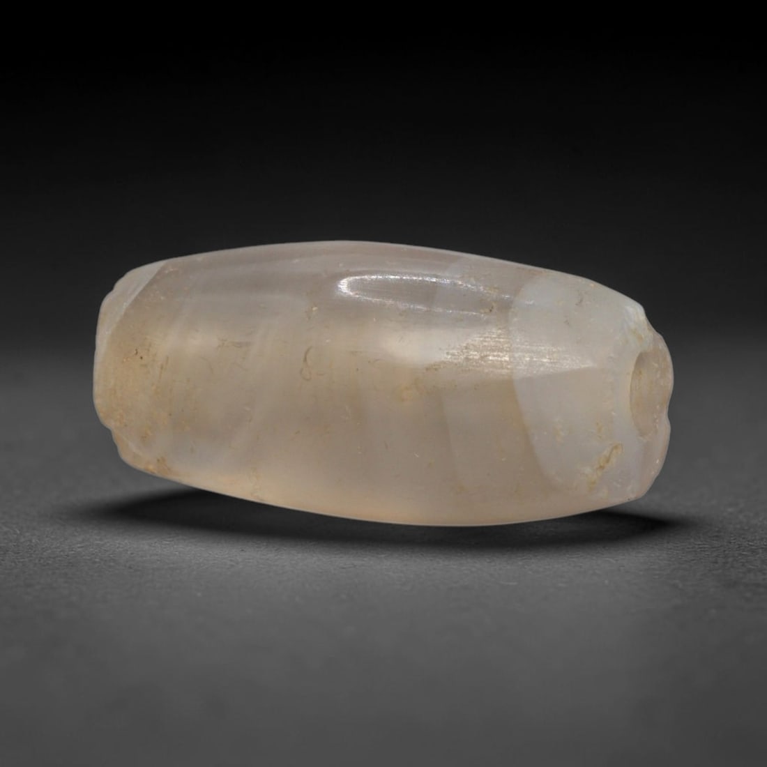 Ancient Translucent Agate Bead - Western Asiatic Miniature Amulet, 3XY: This bead is expertly carved from naturally translucent agate, showcasing fine lapidary craftsmanship consistent with ancient bead-making traditions of the Indus Valley and Bactrian regions. The elong