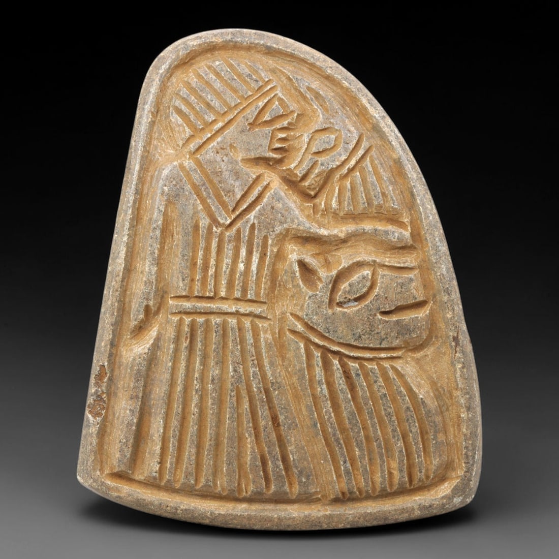 Ancient Stone Plaque Relief - Near Eastern Sphinx Figurine, 3ZY: Carved from a single piece of stone, this bell-shaped relief plaque depicts a stylized sphinx, a composite mythological creature with a lion's body and human head, rendered in the linear, incised arti