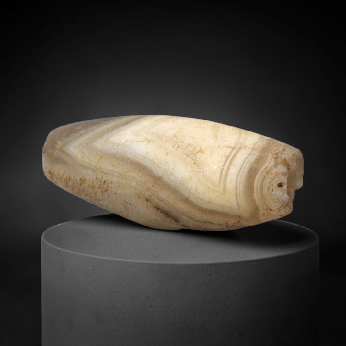 Ancient Banded Agate Bead - Bactrian Western Asiatic Amulet, 74XW: This bead is fashioned from banded agate with distinct creamy white and greyish-brown concentric stratification, characteristic of high-quality lapidary craftsmanship from ancient Bactria and the West