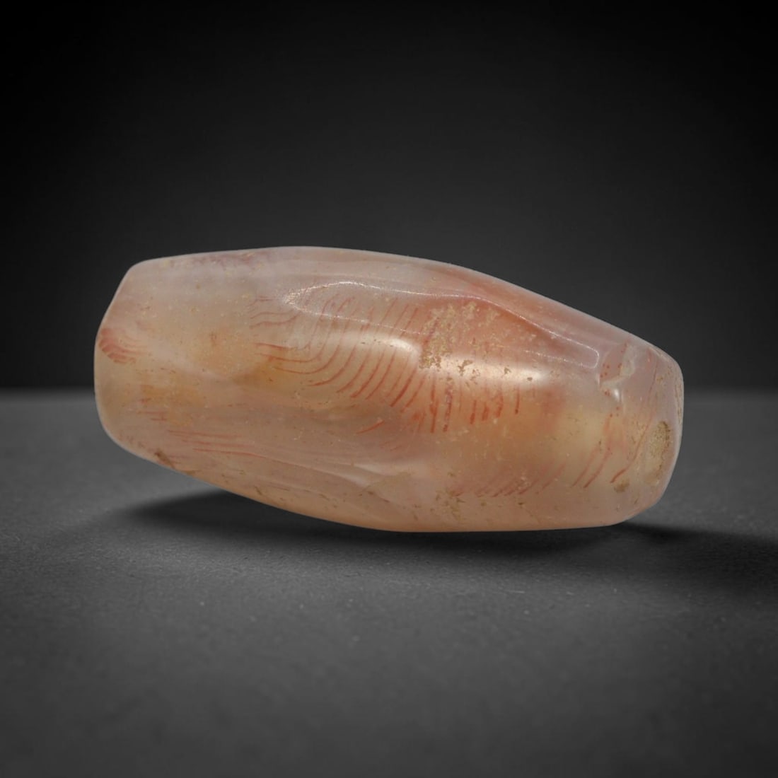 Ancient Agate Bead - Bactrian Engraved Bead, 20XW: This bead is carved from translucent peach-pink agate, shaped into a refined faceted barrel form with a precisely centered axial drill hole, characteristic of ancient Bactrian lapidary craftsmanship d