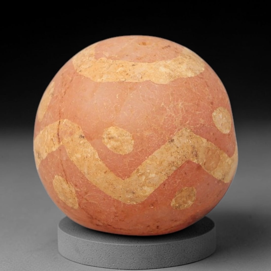 Ancient Carnelian Etched Bead - Gandhara Archaeological Find, 18BE: Carved from natural carnelian, the bead is spherical in form, adorned with white etched geometric motifs including a zigzag band, circular accents, and a top ring design across its surface. A lateral