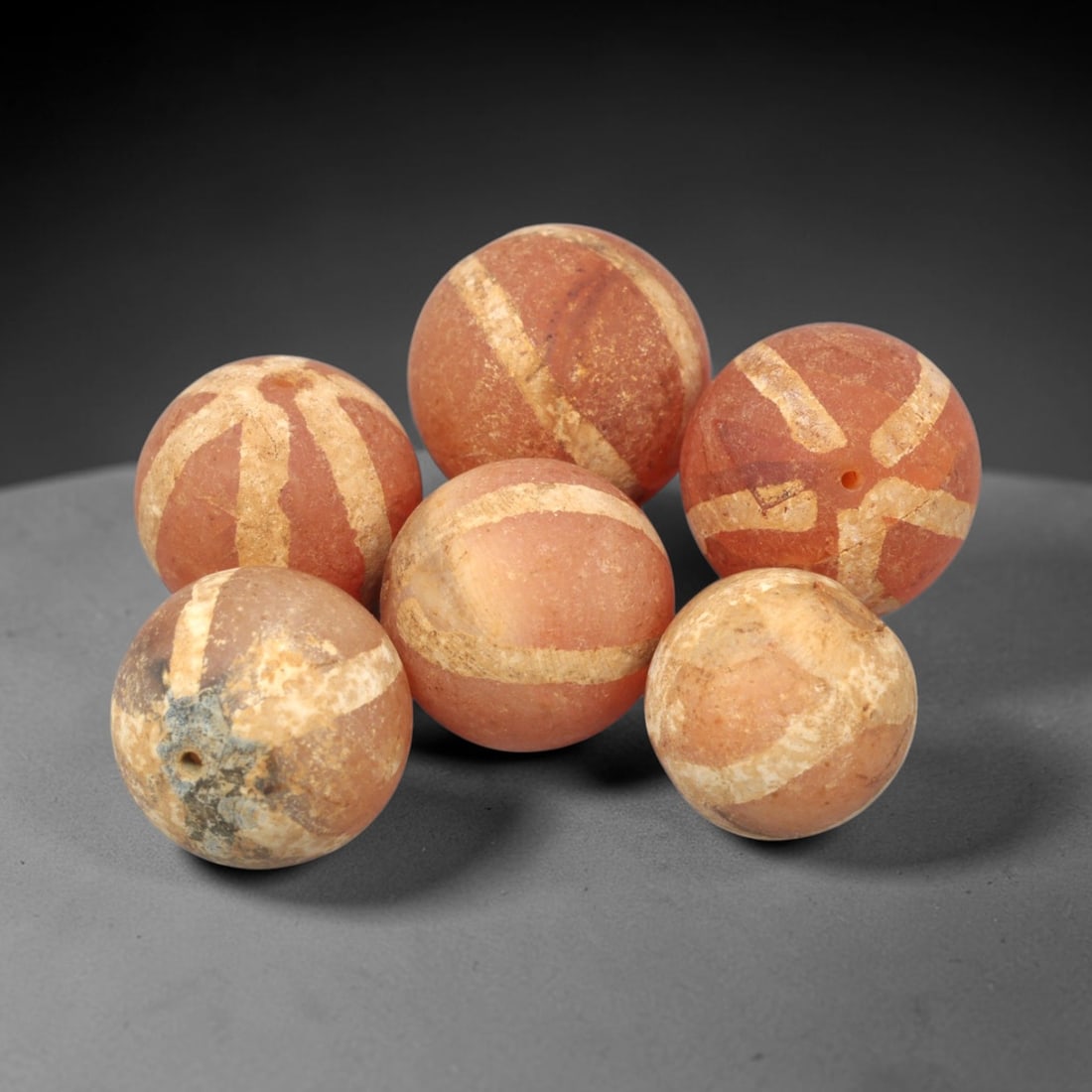 Ancient Carnelian Etched Beads - Gandhara Amulet Set, 72XY: Set of six spherical beads crafted from carnelian, each decorated with etched linear geometric motifs in a pale white pigment, characteristic of Gandharan decorative traditions. The beads retain a wel