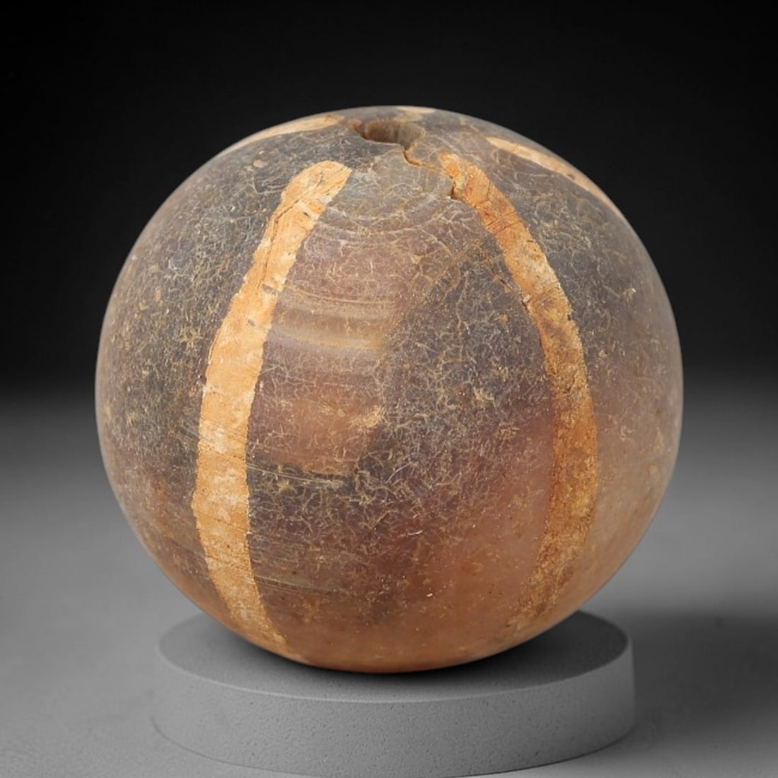 Ancient Carnelian Etched Bead - Gandhara Archaeological Find, 14BE: Carved from natural carnelian, the bead is spherical in form, decorated with white etched vertical linear band motifs across its surface. A lateral drilled suspension hole is present, consistent with