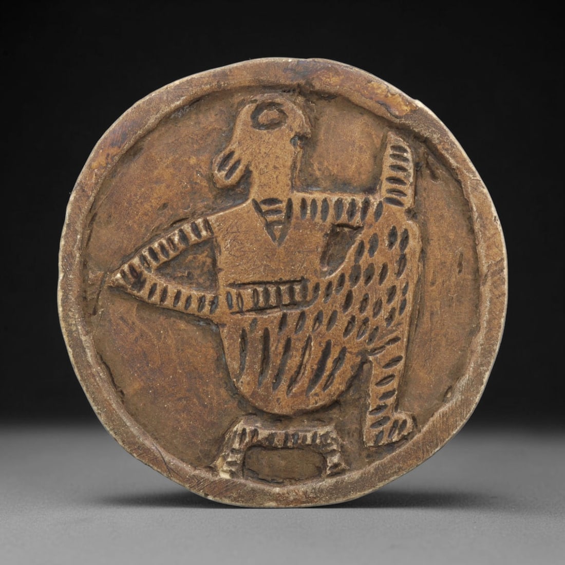 Ancient Steatite Plaque - Near Eastern Anthropomorphic Relief, 28ZY: Carved from steatite, this circular plaque features a relief depiction of a stylized anthropomorphic figure, rendered in the schematic artistic tradition of the Ancient Near East. The figure is shown
