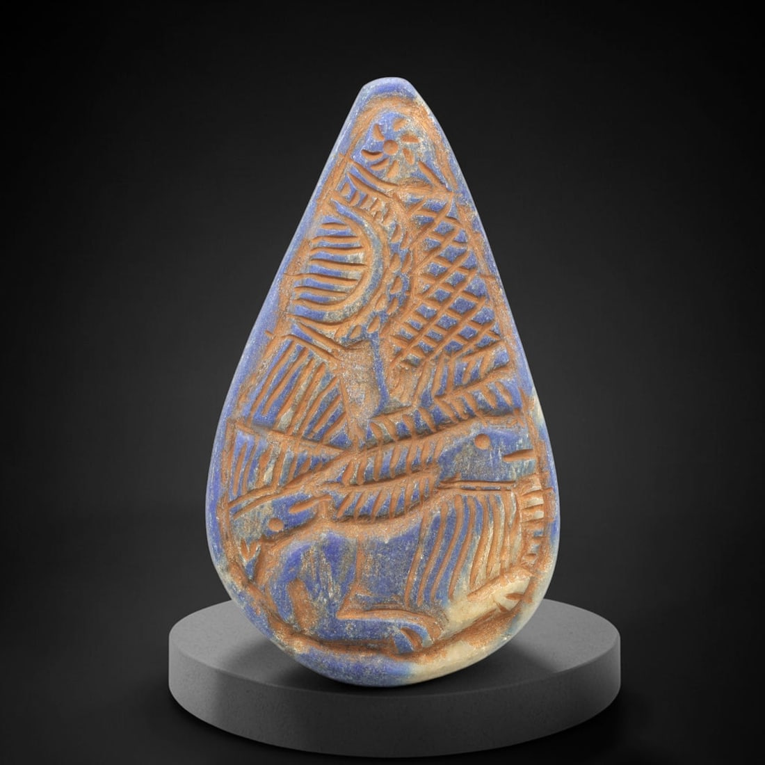 Near Eastern Lapis Lazuli Plaque - Tribal Art Feline & Bird Figure Relief, 60ZY: Carved from lapis lazuli, this teardrop-shaped plaque features a deeply incised relief composition depicting a stylized feline figure below a symbolic bird motif, rendered in a geometric Near Eastern