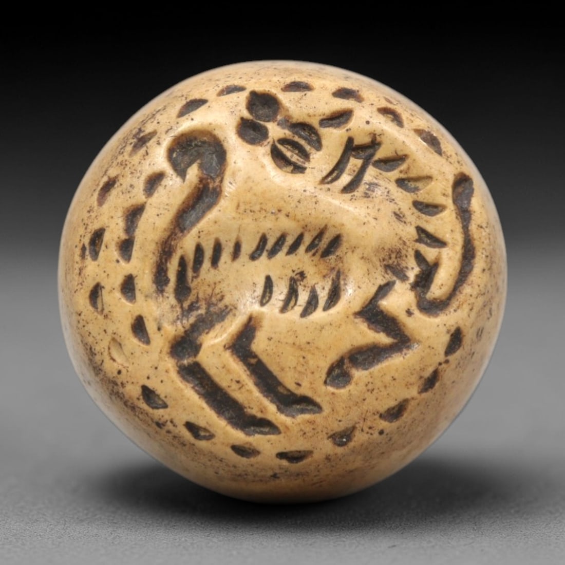 Ancient Conoid Stamp Seal - Near Eastern Zoomorphic Artifact, 7ZR: This artifact is a conoid stone stamp seal, executed in the stylized zoomorphic tradition of the ancient Near East. The circular face depicts a dynamic striding animal (likely a lion or canine) framed