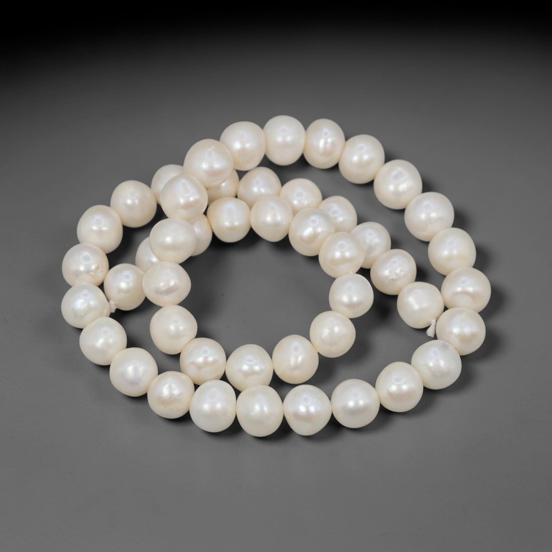 A Strand of Cultured Pearls, 20th Century, 78ZJ: Composed of uniformly sized, near-round cultured pearls with a creamy white body color and subtle pinkish overtones, the strand is strung in a single continuous line. Each pearl exhibits a soft, lustr