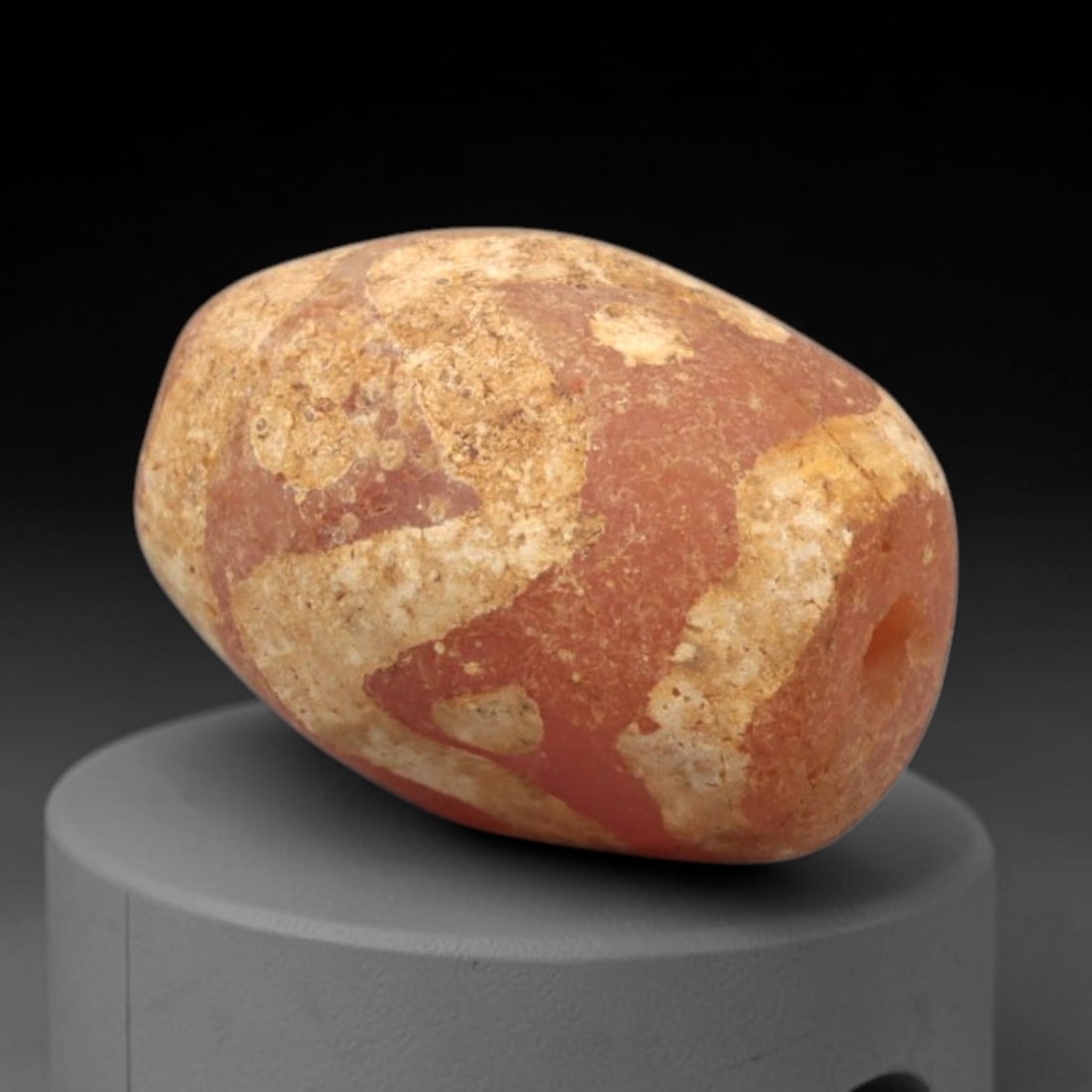 Ancient Carnelian Etched Bead - Gandhara Amulet, 32XY: Carved from carnelian, the bead is fashioned in an oval barrel form with a lateral drilled suspension hole for wear. The surface bears a partial white-etched curvilinear pattern, characteristic of Gan