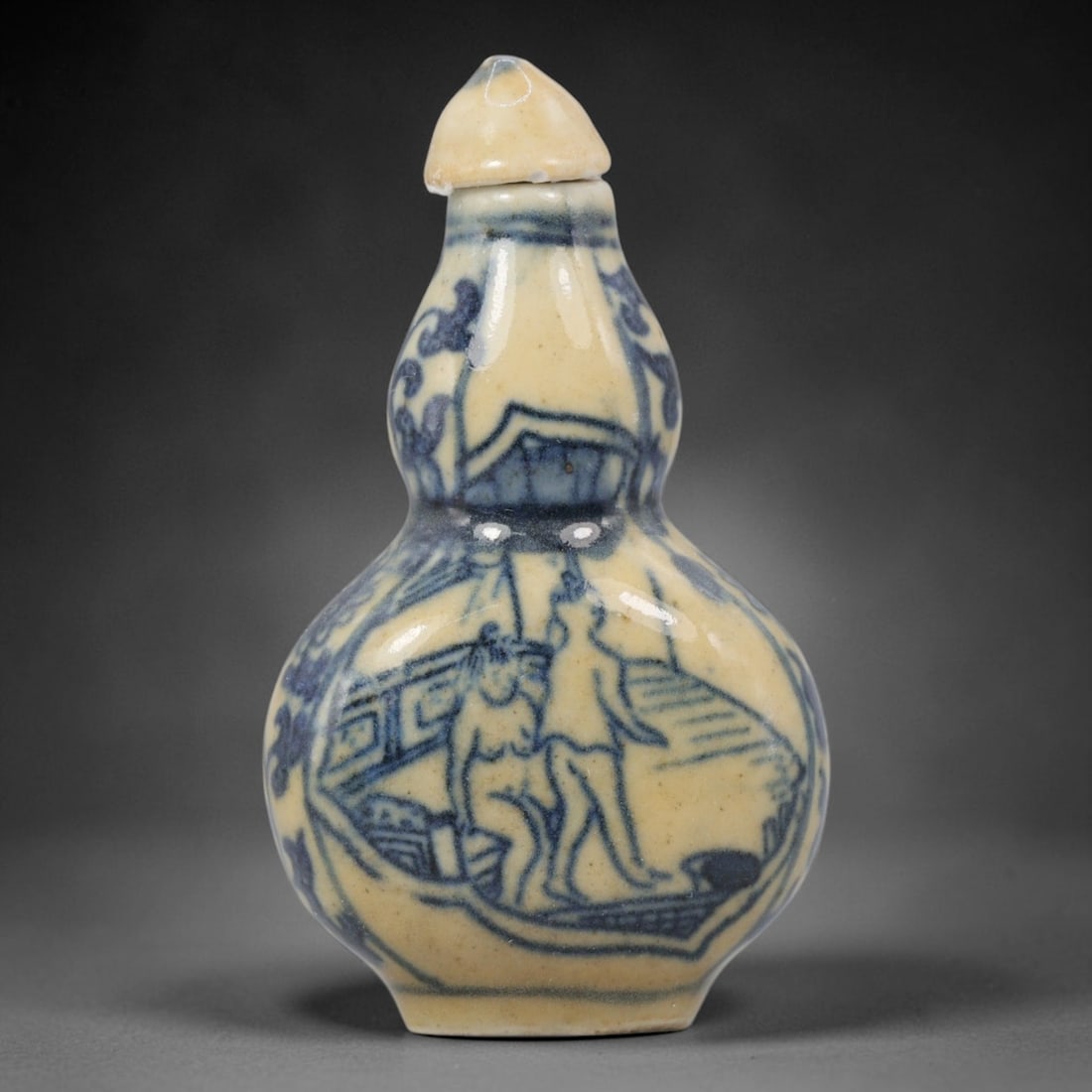 A Chinese Porcelain Double-Gourd Snuff Bottle, 20th Century, 50BE: Crafted from porcelain with a pale cream glaze and decorated in underglaze blue, the snuff bottle is formed in a double-gourd shape, with a narrow upper bulb, a wider lower bulb, and a short neck fitt