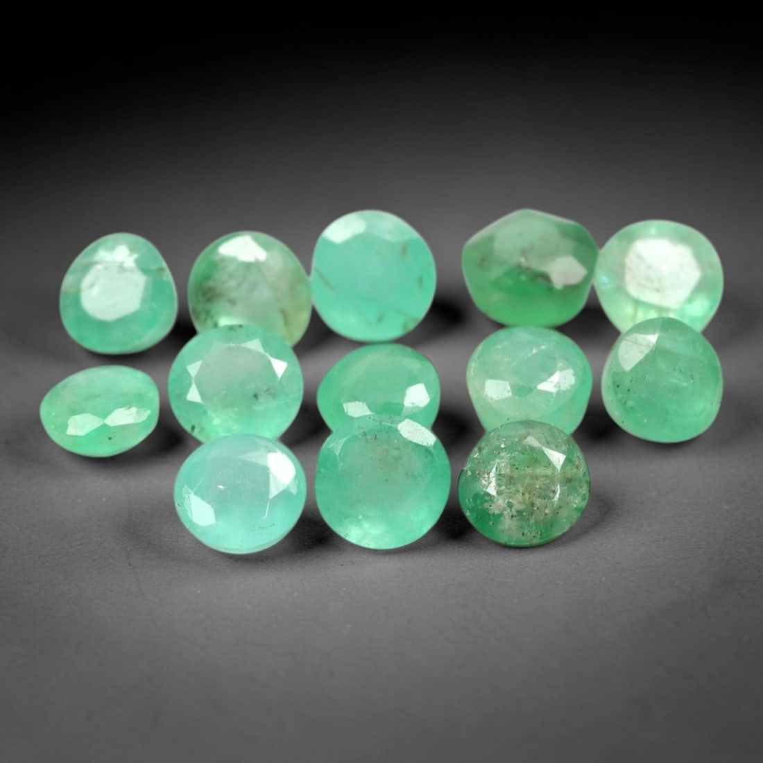 1.22 Carats Round Mixed-Cut Zambia Emerald Parcel - Natural Zambian 2.2mm, 76XM: This parcel of round mixed-cut emeralds from Zambia showcases a vibrant, grassy green hue, characteristic of fine Zambian gemstones. Each stone exhibits subtle natural inclusions and a lively luster,