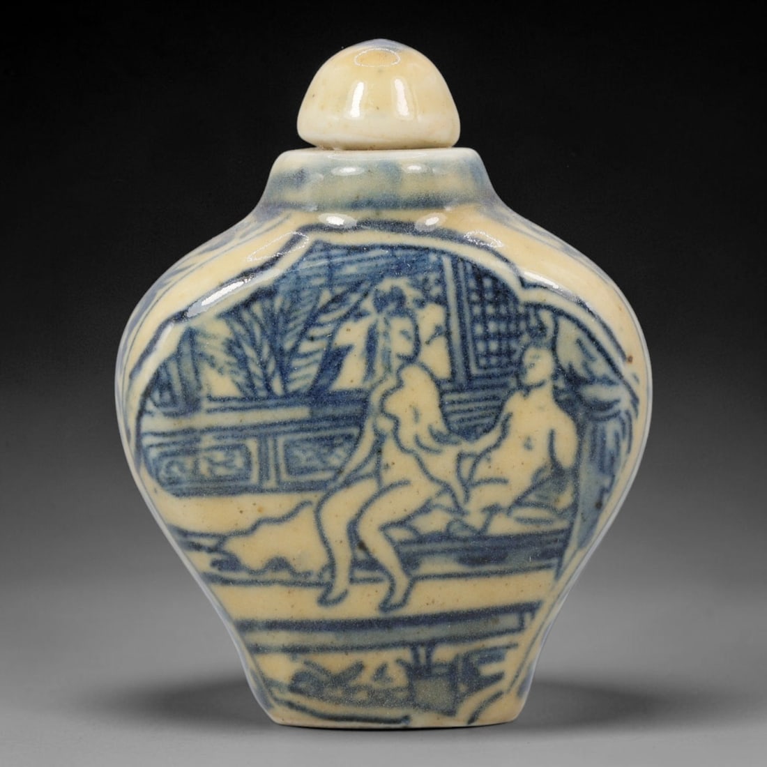 A Chinese Porcelain Snuff Bottle, 20th Century, 57BE: Crafted from porcelain with a pale cream glaze and decorated in underglaze blue, the snuff bottle features a flattened, faceted globular body, a short cylindrical neck, and a domed stopper. The main s