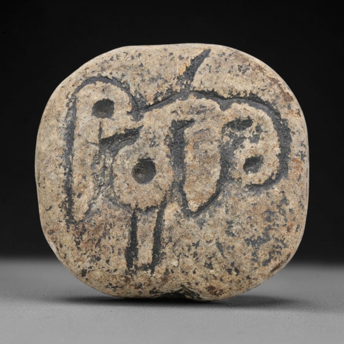 Ancient Stone Stamp Seal - Near Eastern Carved Amulet, 98ZT: Carved from natural pebble stone, the stamp seal features a deeply incised stylized zoomorphic motif, rendered with bold linear carving and raised circular bosses for the eyes and central detail. The