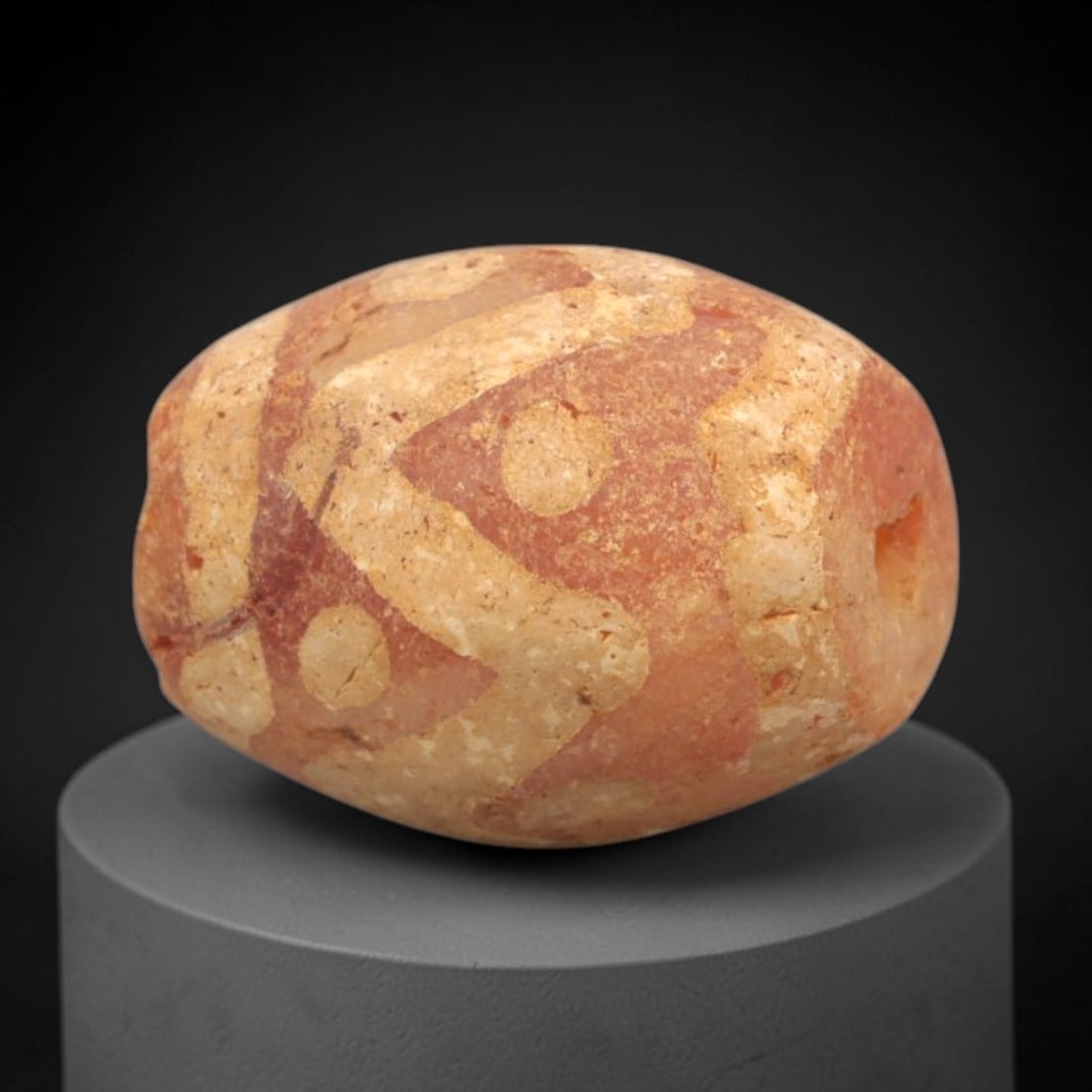 Ancient Carnelian Etched Bead - Gandhara Amulet, 47XY: Carved from carnelian, the bead is fashioned in an oval barrel form with a lateral drilled suspension hole for wear. The surface is adorned with intricate white-etched geometric motifs, including inte