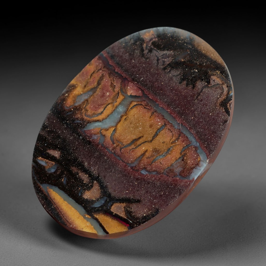 4.34 Carats Koroit Boulder Opal Cabochon - Natural Australian Stones 13.3x9.3mm, 4XM: This striking 4.34-carat Koroit boulder opal cabochon is a natural geological masterpiece, featuring a dramatic banded ironstone matrix with layered hues of deep plum, warm terracotta, and golden ochr