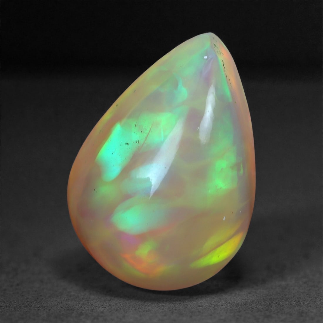 3.56 Carats Play-of-Color Welo Opal - Natural Ethiopian Gem 13x9mm, 25XA: This captivating Welo opal gleams with a luminous cascade of multi neon color that ripple across the stone's surface with every movement. The play-of-color is vivid and well-distributed, presenting a