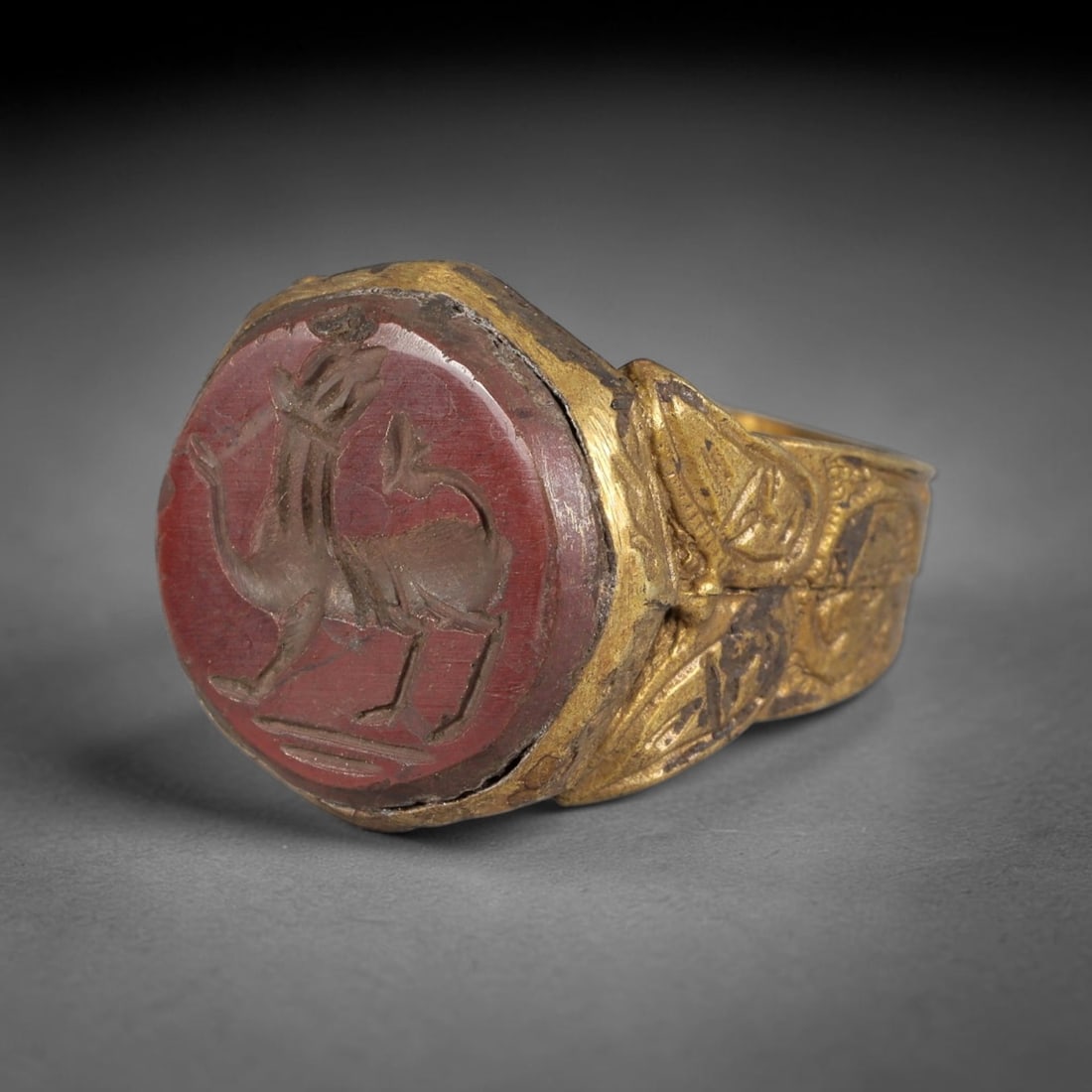 Antique Qajar Dynasty Carnelian Intaglio Brass Ring - Size 9 US, 69BA: Crafted from brass, this ring features an octagonal carnelian intaglio panel carved with a stylized camel, executed in the traditional Qajar style. The brass band displays ornate, relief-carved metalw