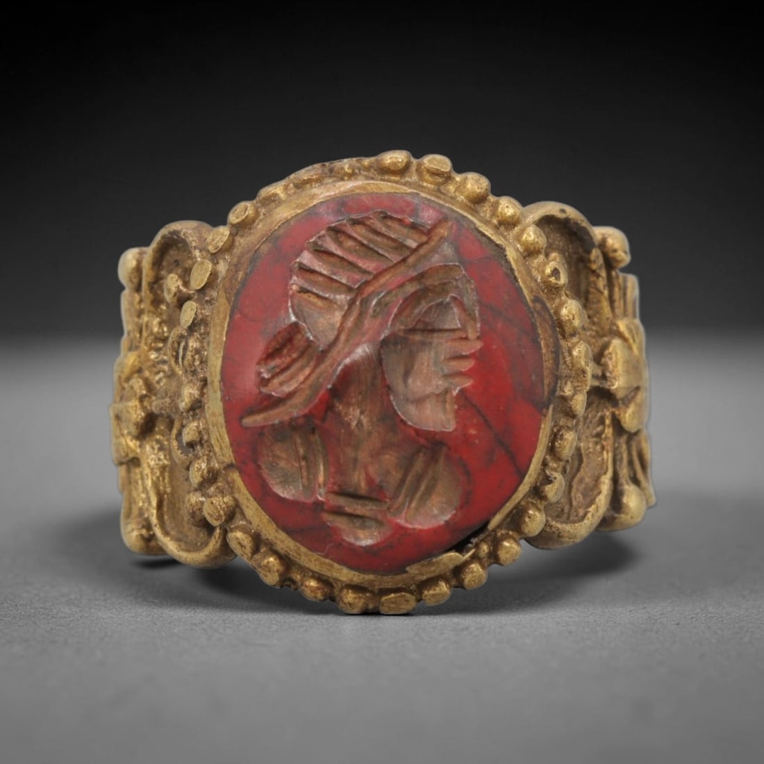 Antique Qajar Dynasty Brass Intaglio Ring - Size 10 US, 83ZX: This antique Qajar dynasty brass intaglio ring features a finely carved bust motif, set within an ornate beaded brass mount. The ring is crafted from brass, with a red-stone intaglio inset displaying