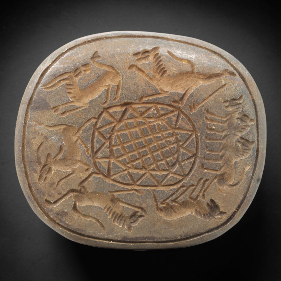 Near Eastern Tribal Stone Plaque Relief - Animal Motif Decorative Plaque, 8ZY: Carved from a single piece of stone, this oval relief plaque features a dynamic circular composition in the stylized, linear artistic tradition of Near Eastern tribal art. A central geometric grid mot