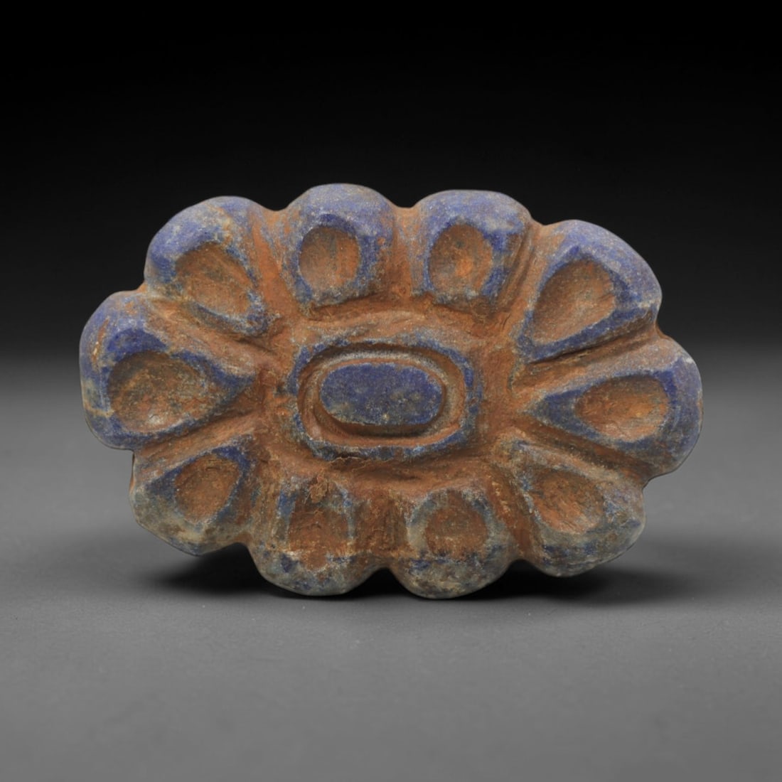 Ancient Lapis Lazuli Amulet - Near Eastern Petal Motif, 9ZQ: Carved from deep blue lapis lazuli, this amulet features a stylized petal and floral motif with incised linear detailing. The stone exhibits natural pyrite inclusions and a subtle, aged patina consist