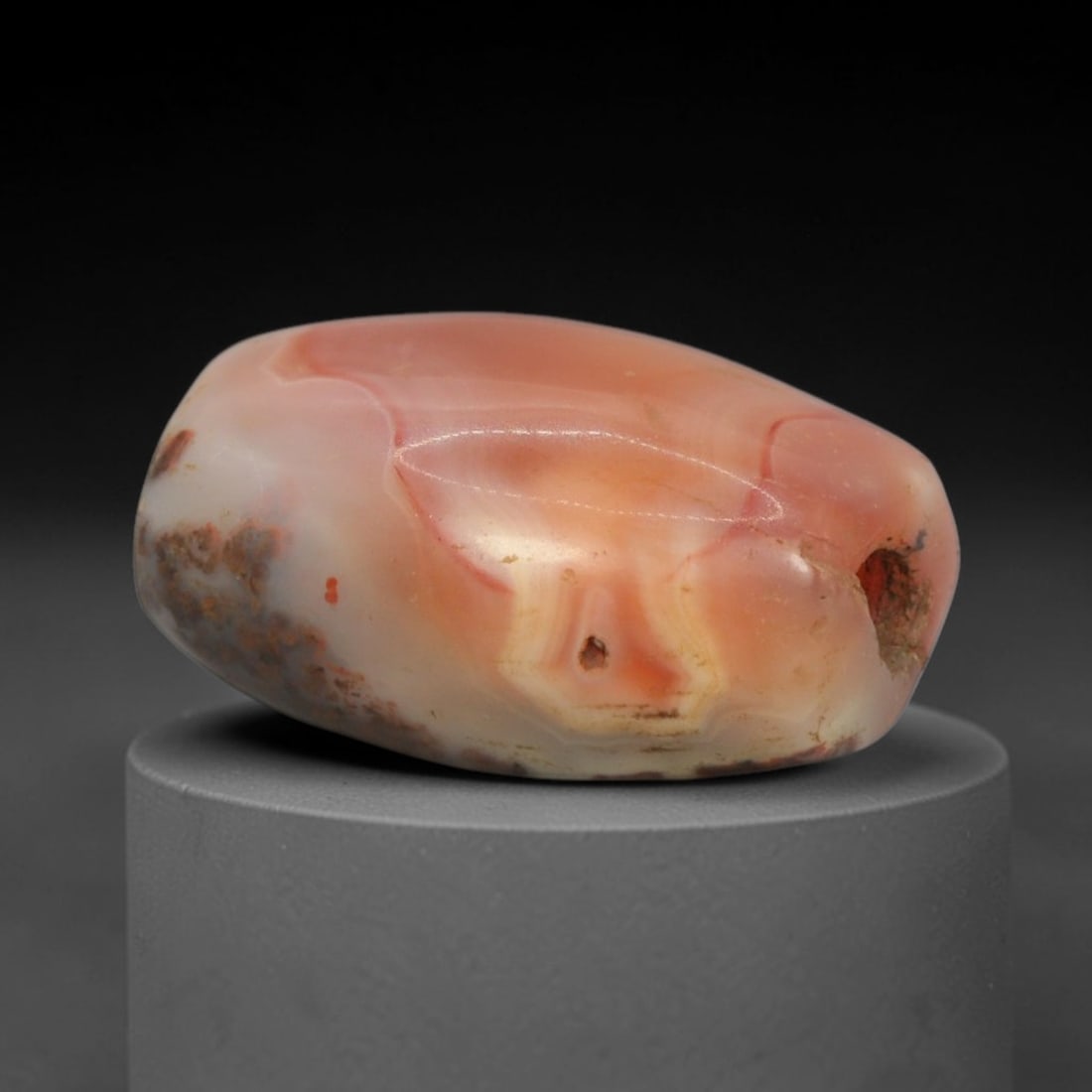 Ancient Agate Bead - Indus Valley Pink Banded Carnelian Bead, 35XW: This bead is carved from translucent soft pink and creamy-white banded carnelian agate, shaped into a smooth, organic oval (amygdaloid) form with a precisely centered axial drill hole, characteristic