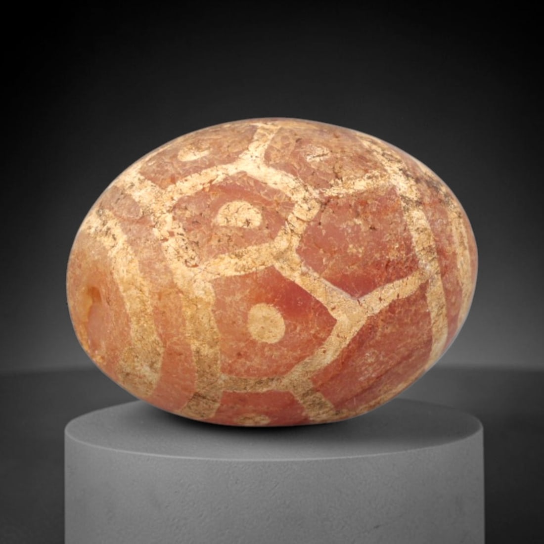 Ancient Carnelian Etched Bead - Gandhara Amulet, 52XY: Carved from carnelian, the bead is fashioned in a rounded oval form with a lateral drilled suspension hole for wear. The surface is decorated with a white-etched geometric pattern of interlocking hexa