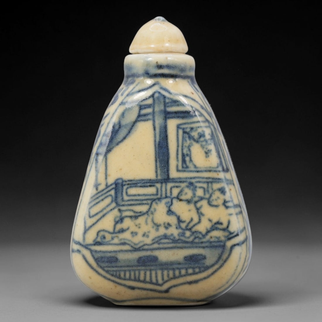 A Chinese Porcelain Snuff Bottle, 20th Century, 53BE: Crafted from porcelain with a pale cream glaze and decorated in underglaze blue, the snuff bottle features a flattened, tapering pear-shaped body, a short cylindrical neck, and a domed stopper. The ma