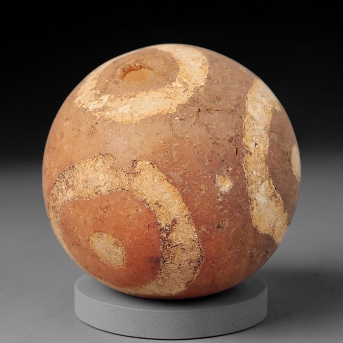 Ancient Carnelian Etched Bead - Gandhara Archaeological Find, 17BE: Carved from natural carnelian, the bead is spherical in form, decorated with white etched circular and banded motifs across its surface. A lateral drilled suspension hole is present, consistent with G
