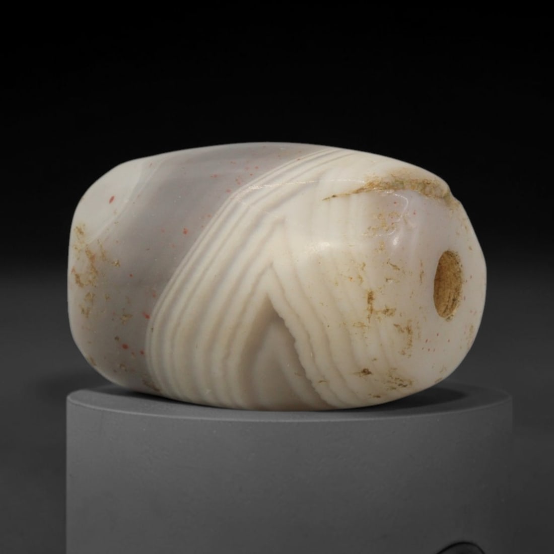 Ancient Agate Bead - Bactrian Banded Cylinder Bead, 60XW: This bead is fashioned from translucent milky-grey banded agate, shaped into a smooth, compact cylindrical form with a precisely centered axial drill hole, characteristic of ancient Bactrian lapidary