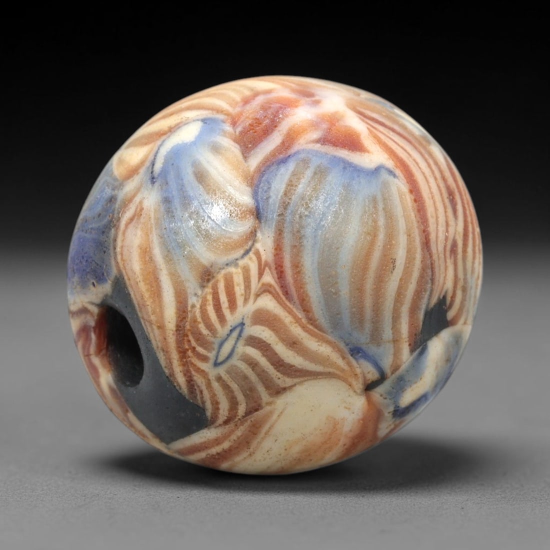 Ancient Mosaic Glass Bead - Roman Egyptian Style Amulet, 71WD: This bead is crafted from mosaic glass, featuring a spherical form adorned with intricate layered glass canes in hues of deep blue, soft cream, and warm terracotta. The decorative pattern consists of 