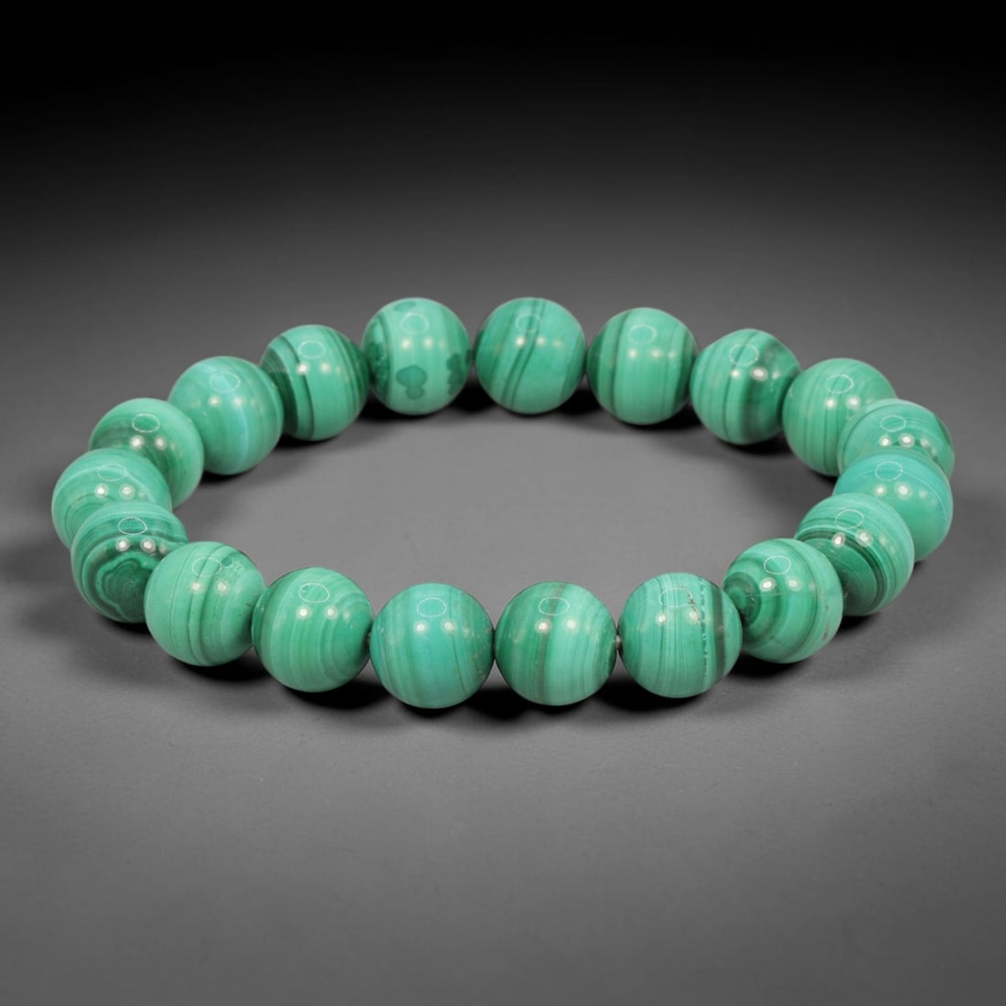 Malachite Bead Bracelet - Round Polished Gemstone, 69WE: This bracelet is crafted from uniformly sized, round malachite beads, each exhibiting the mineral's characteristic vibrant green color and distinct concentric banding patterns. The beads are smoothly