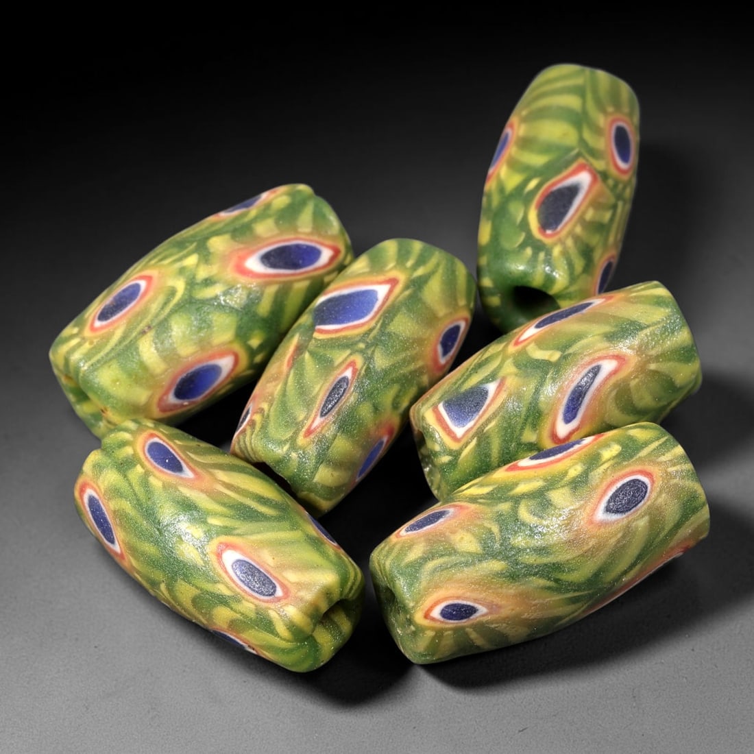 Old Glass Eye Beads - Phoenician Style Cylindrical Beads, 86BG: Set of six cylindrical old glass eye beads, crafted from fused colored glass segments to create a repeating concentric eye motif across each surface. Each bead features raised dark blue central eyes s