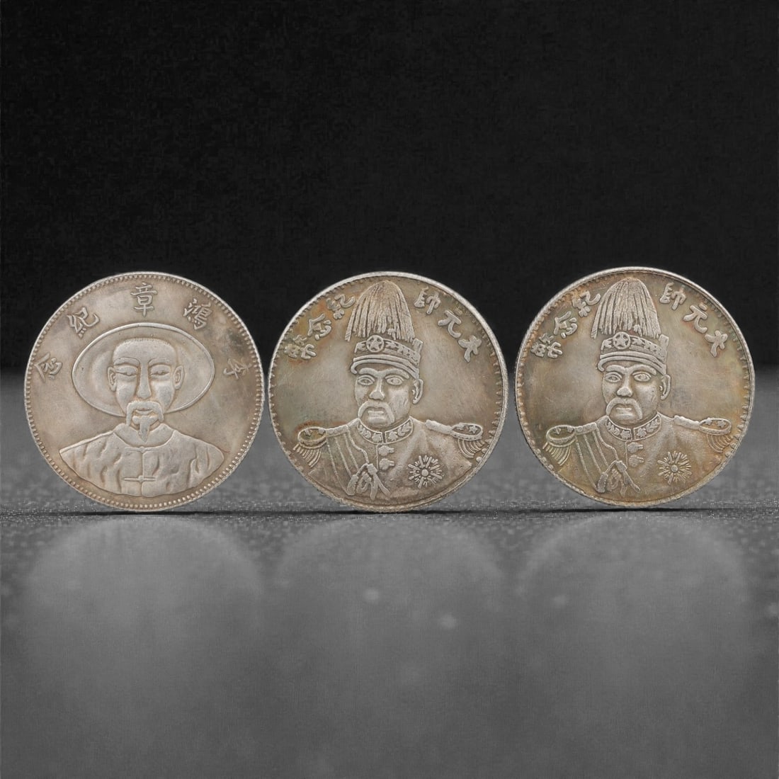 Three Chinese Commemorative Medallions Coins, 20th Century, 81FN: The group comprises three circular commemorative medallions, each with a diameter of 3.9 cm (1 1/2 in.). The first medallion depicts a portrait of a historical figure in traditional attire at its cent