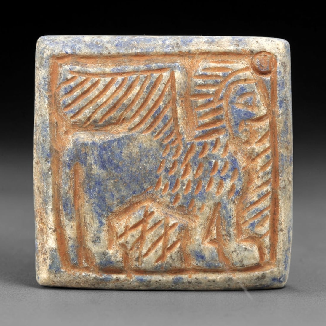 Near Eastern Lapis Lazuli Plaque - Tribal Art Animal Relief, 24ZA: Carved from natural lapis lazuli stone, this Near Eastern tribal art plaque relief features a hand-carved depiction of a stylized animal motif, executed with incised linear and dotted techniques that