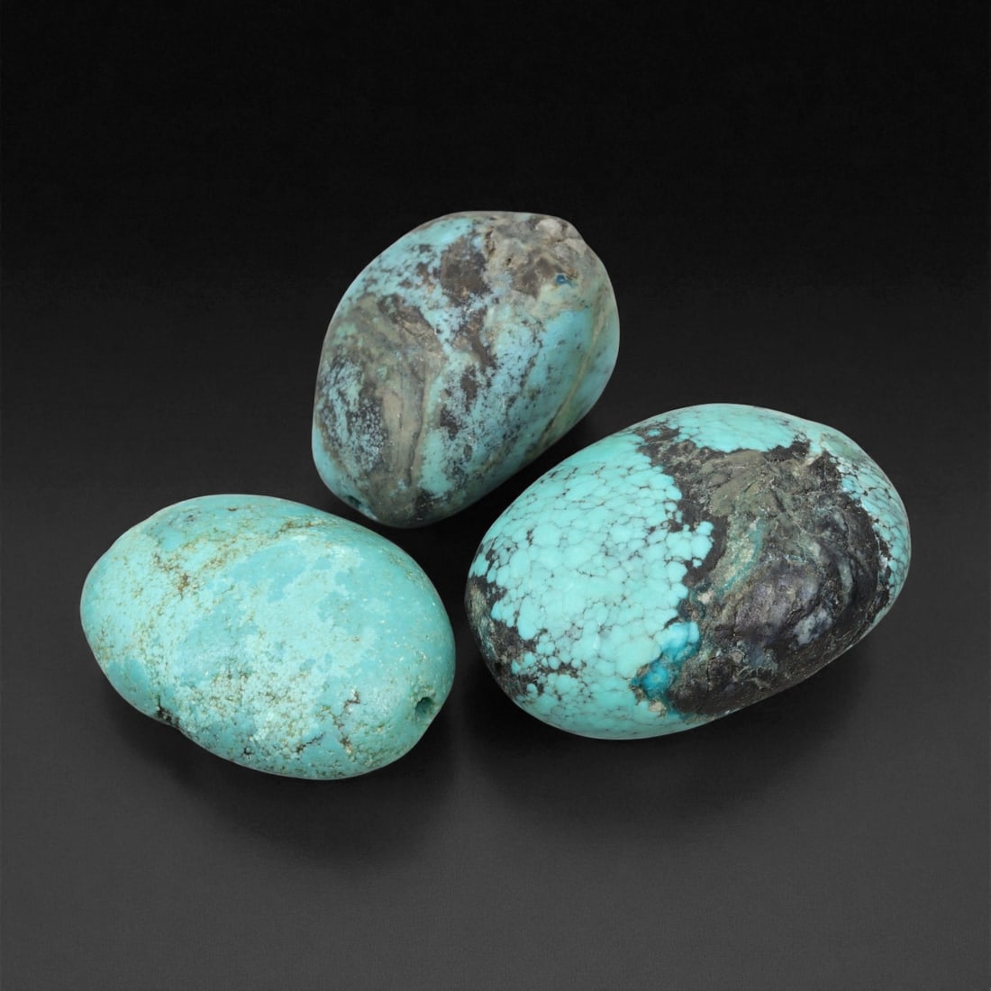 A Group of Three Tibetan Turquoise Beads, 20th Century, 34EX: A set of three substantial, barrel-shaped Tibetan turquoise beads, each exhibiting the characteristic vibrant sky-blue hue and natural matrix inclusions of authentic Himalayan turquoise. The beads var
