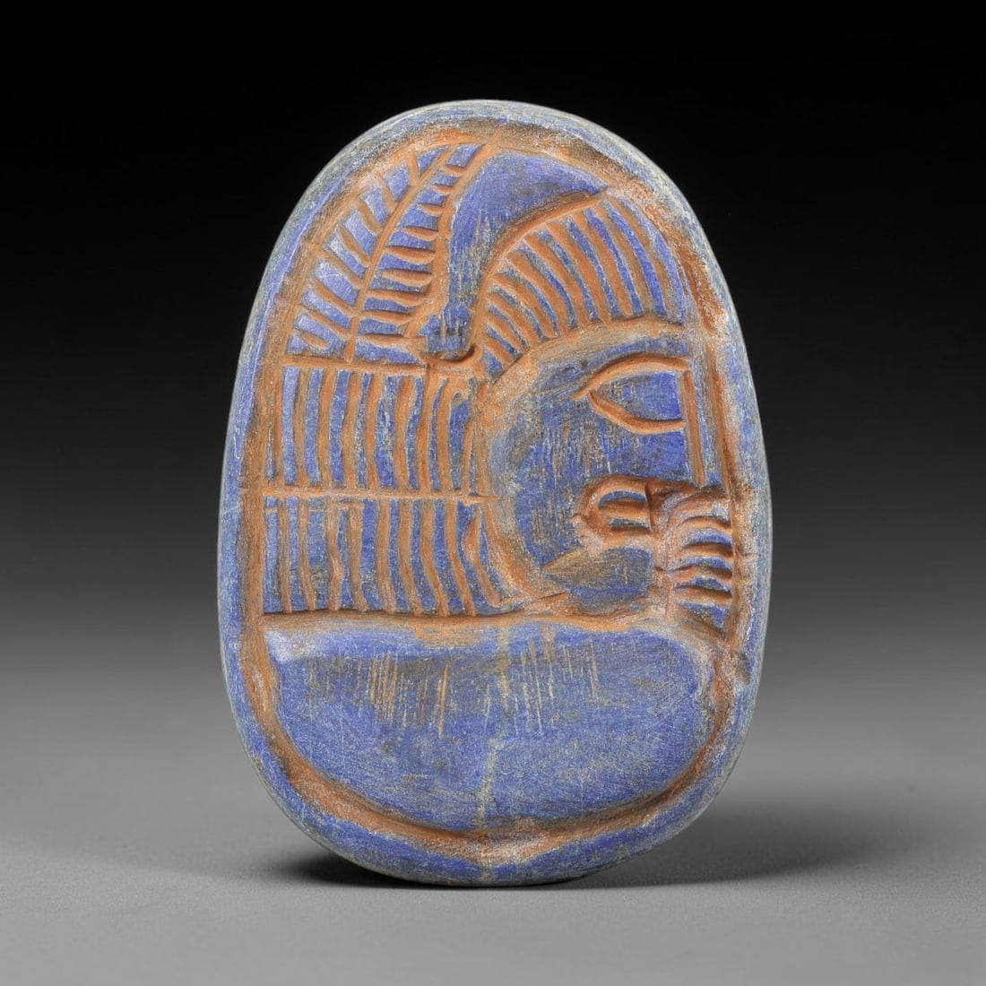Near Eastern Lapis Lazuli Plaque - Tribal Art Figure Relief, 99BF: Carved from lapis lazuli, this oval plaque features a relief depiction of a stylized human figure in profile, executed in the expressive, linear style characteristic of Near Eastern tribal art. The fi