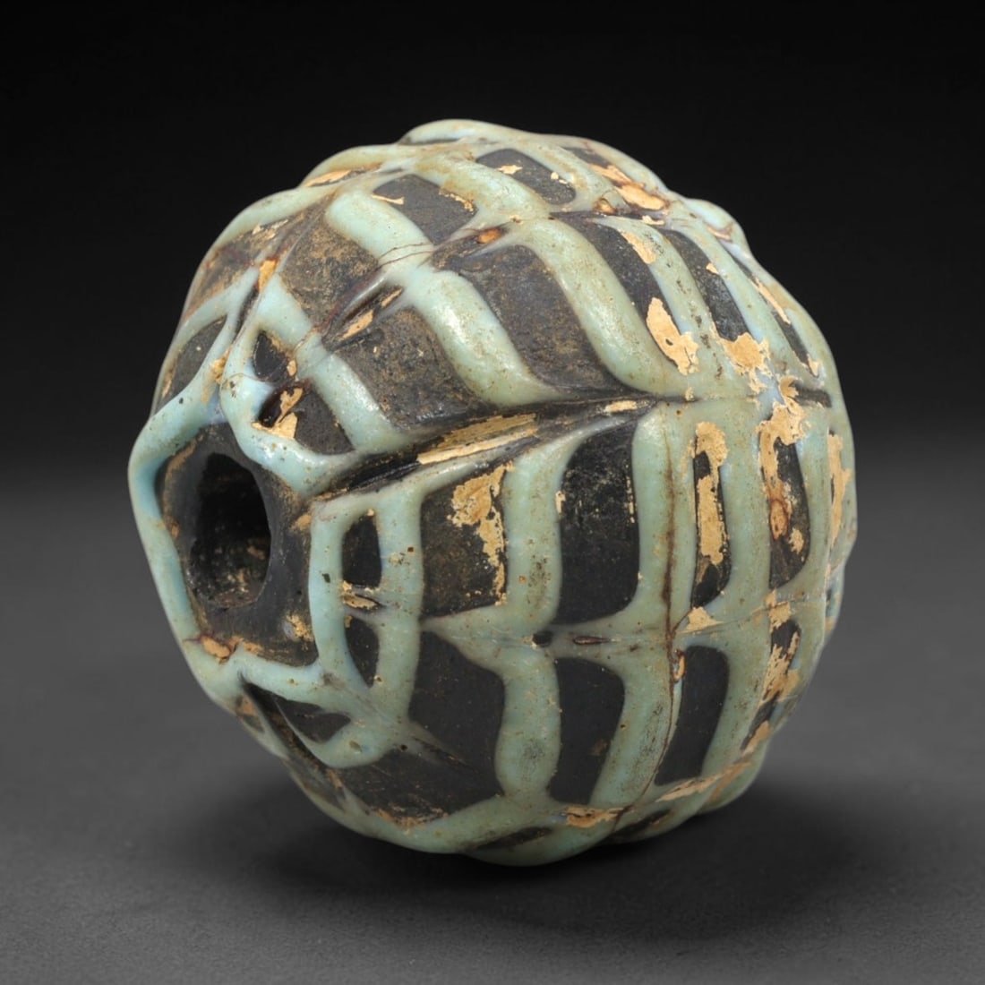 Ancient Glass Lattice Bead - Central Asian Islamic Amulet, 37WD: A substantial spherical glass bead crafted from dark core glass, decorated with a raised, three-dimensional lattice pattern in opaque pale turquoise glass across the entire surface. The bead features 